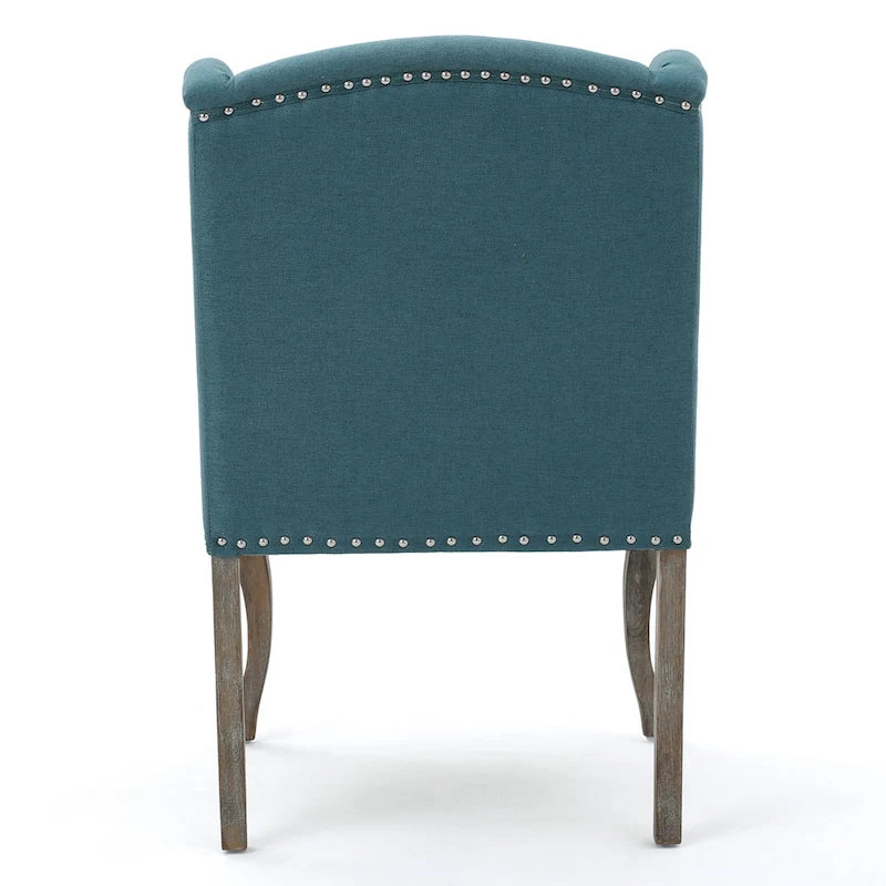 Sillón decorativo de una plaza con respaldo alto, color verde azulado, con botones capitoné y estructura de madera de caucho
